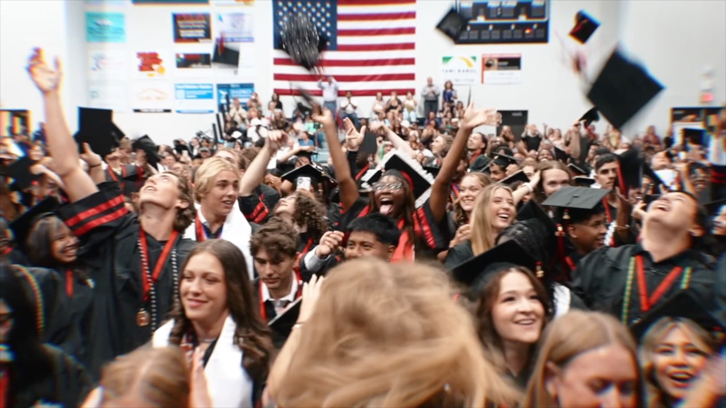 Graduates celebrating and tossing caps at a Martin County high school graduation
