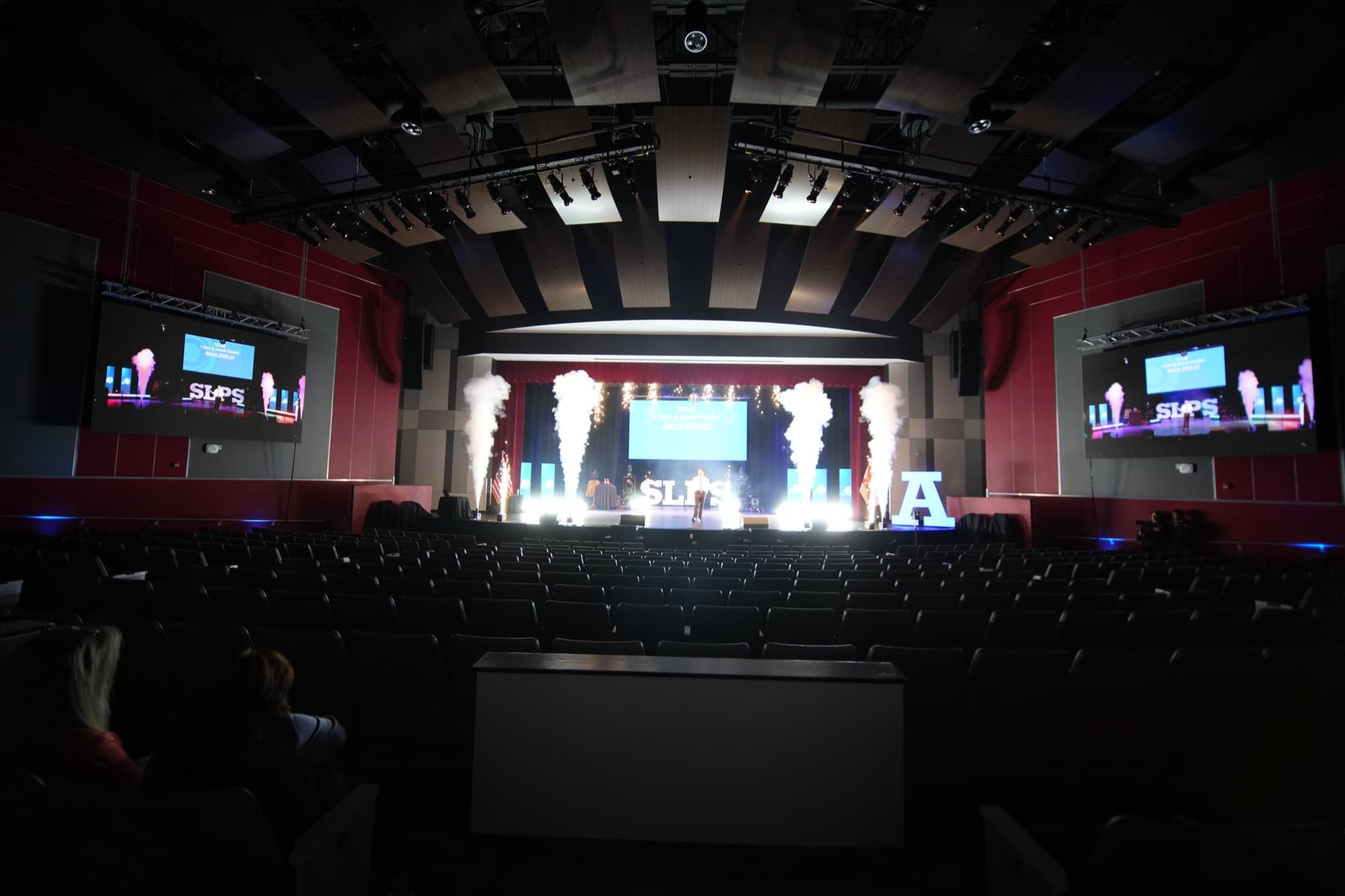 Wide shot of the SLPS kickoff stage with pyrotechnics and branded signage